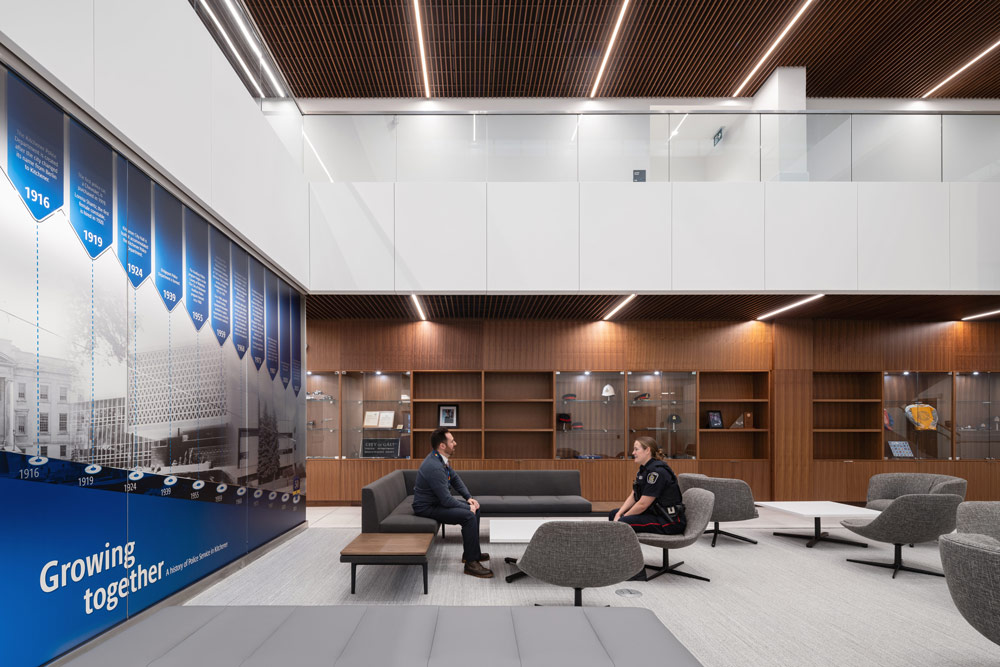 Main atrium with a lounge are and seating, next to a wall featuring a large infographic on the history of the organization.