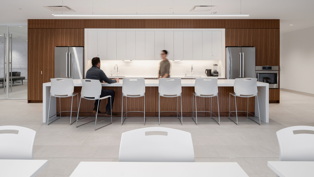 In the lunchroom area, a wood and white finish kitchen and large island with bar stools.