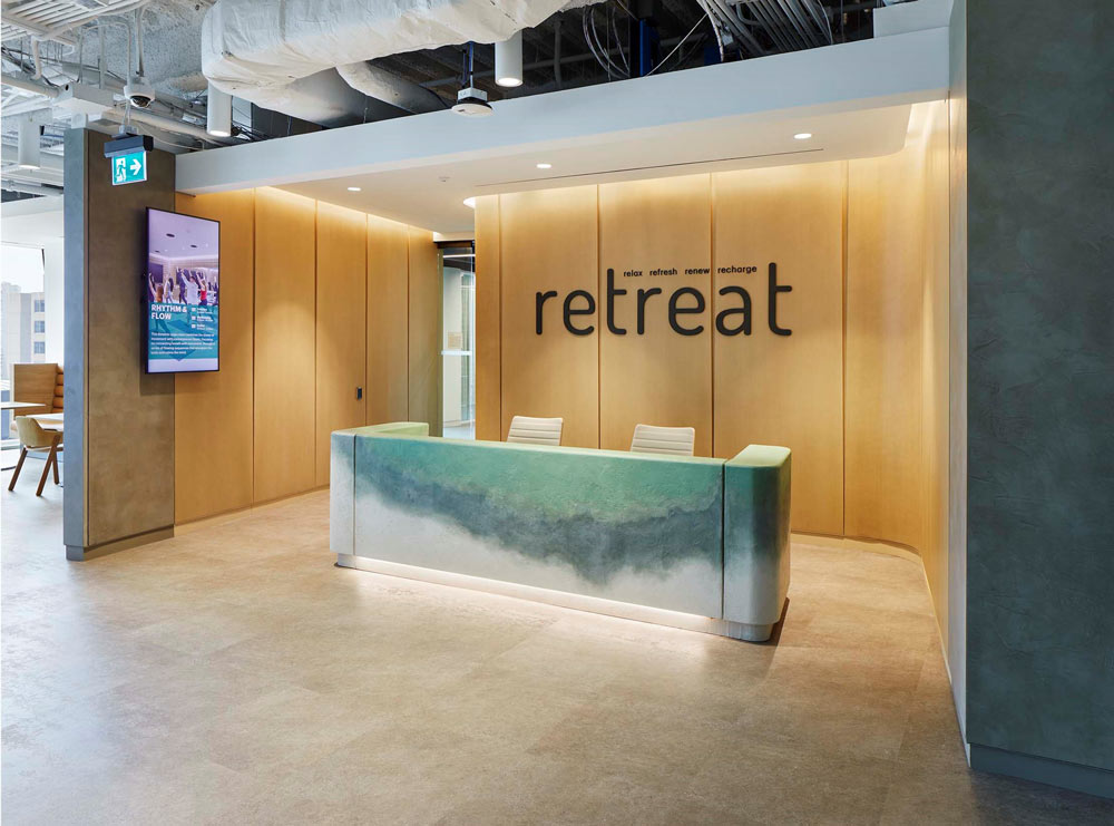 A reception desk at the entrance to a wellness area. The reception desk has a marble like gradient pattern in green and blue-gray and white
