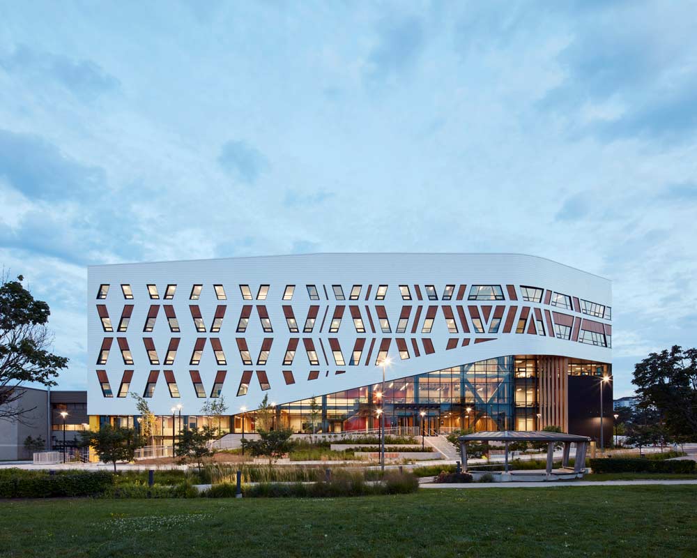 The exterior of the Centennial A building showing the white feature covering half of the building diagonally with a woven pattern