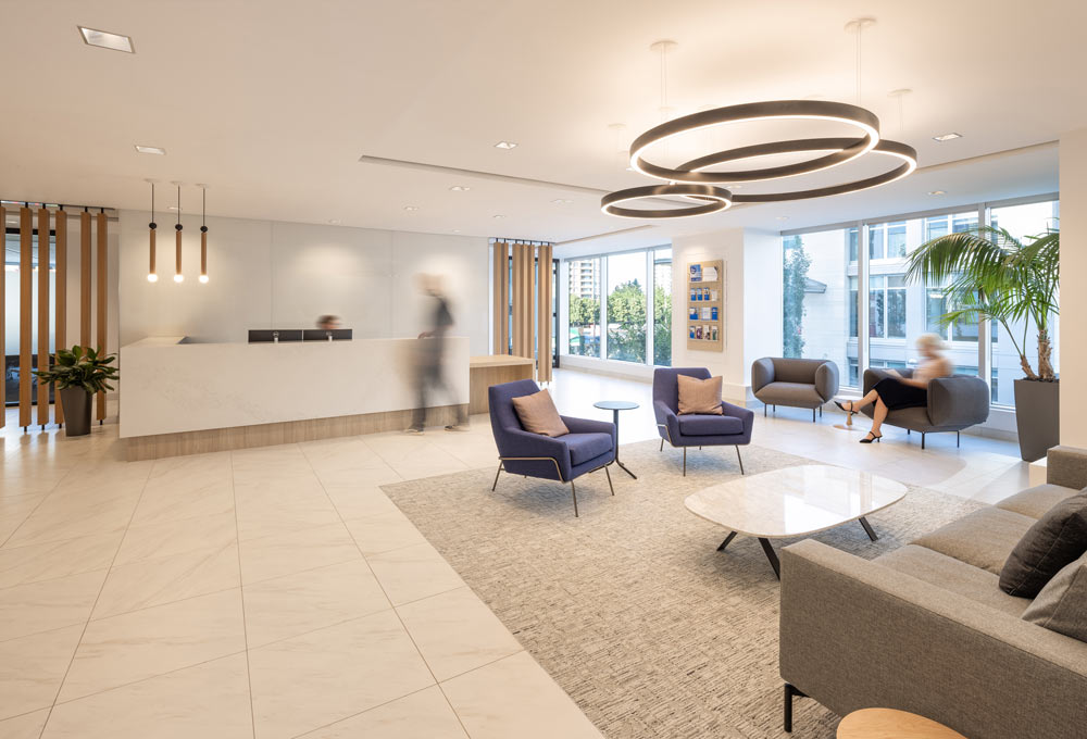 Reception area with in mostly neutral cream, white and gray, with some wooden accents and details.