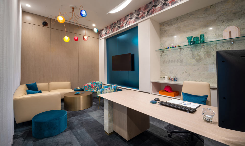 An example of an office custom designed for executive with an inviting lounge seating area and colourful pops throughout