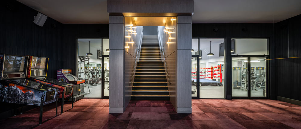 A staircase in the middle leads down to  the gym area and retro arcade games in the hallway beside the staircase