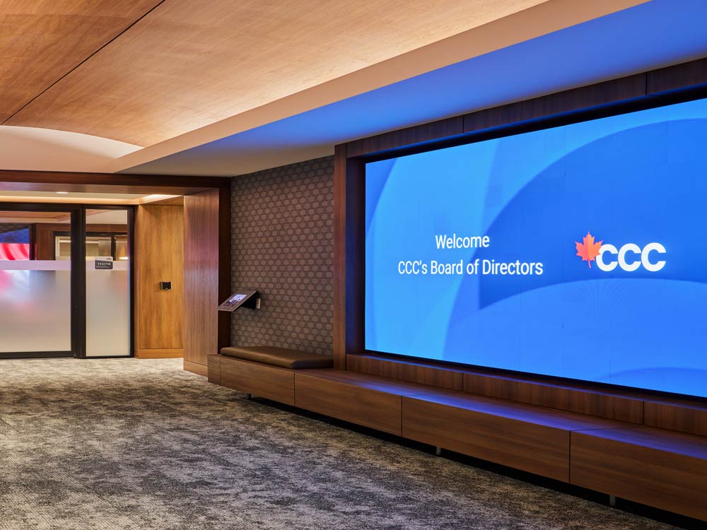 The front lobby of Canadian Commercial Corporation with a huge screen on the wall displaying the company name, leading to the main entrance of the office